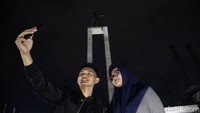 Dua orang pengunjung tampak asyik berfoto di kawasan Lapangan Banteng, Jakarta, di kala malam, Rabu (4/3/2020).
