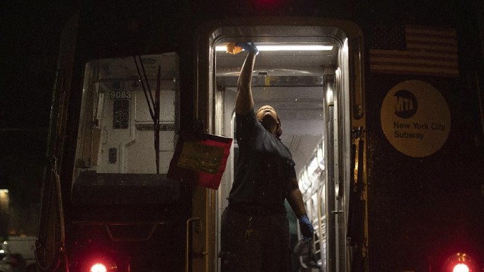A Metropolitan Transportation Authority worker sanitizes surfaces at the Coney Island Yard, Tuesday, March 3, 2020, in the Brooklyn borough of New York. The MTA is stepping up efforts to sanitize cars and stations as fears mount over the coronavirus. (AP Photo/Kevin Hagen)