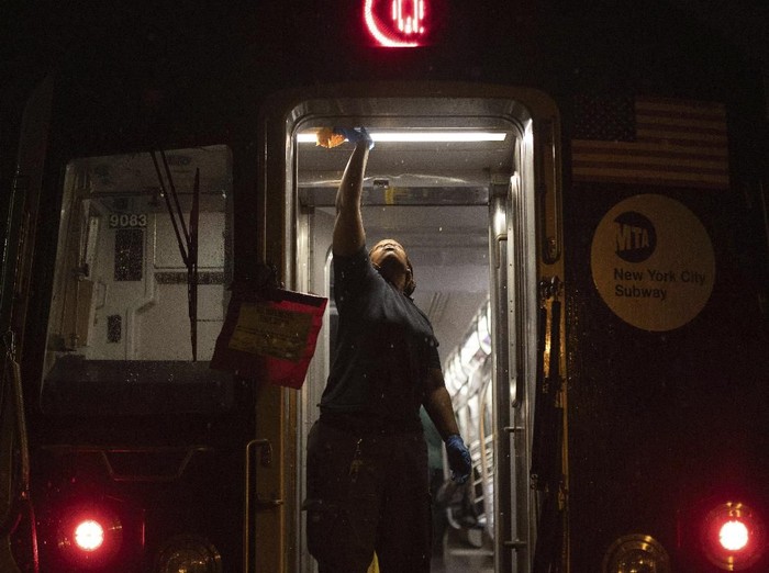 A Metropolitan Transportation Authority worker sanitizes surfaces at the Coney Island Yard, Tuesday, March 3, 2020, in the Brooklyn borough of New York. The MTA is stepping up efforts to sanitize cars and stations as fears mount over the coronavirus. (AP Photo/Kevin Hagen)