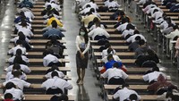 Tak hanya para siswa, para pengawas di ujian tersebut juga turut mengenakan masker pelindung pernapasan.