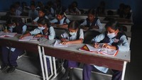Sejumlah siswa tampak mengenakan masker saat mengikuti kegiatan belajar mengajar di sekolah yang berada di Hyderabad, India.
