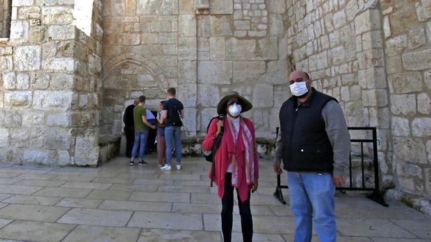 People wearing masks visit the Church of the Nativity, revered as the birthplace of Jesus Christ, in the West Bank city of Bethlehem on March 5, 2020. - The Palestinian health ministry called for local churches, mosques and other institutions to close after suspected cases had been detected at the hotel in the Bethlehem area, the first in the Palestinian territories. (Photo by Musa Al SHAER / AFP)