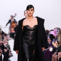 Model kelahiran Belanda ini menebar pesonanya dengan busana serba hitam. Jill memakai gaun kulit berbelahan tinggi pada bagian rok, berikut mantel hitam berpotongan minimalis sebagai luaran. Gayanya juga dilengkapi heels merah yang dihiasi motif kelopak bunga tiga dimensi. (Foto: Getty Images/Pascal Le Segretain)