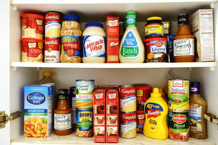 West Palm Beach, USA - October 28, 2011: This is a studio closeup shot of a selection of brand name groceries. In full view are Bushs baked beans, Planters peanuts, Frenchs mustard and fried onions, Folgers coffee, Bumblebee tuna fish, and Nutella cocoa spread. Other products are partially visible in the background. This is a collection of some of the basic staples found in many American kitchens.