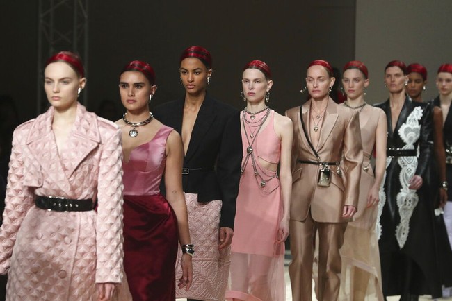 Dominasi Jill Kortleve berlanjut di fashion show Alexander McQueen. Jill (berada di barisan kedua) muncul dalam balutan dress dua warna, pink dan merah, yang dihiasi aksesori silver berupa statement necklace dan gelang futuristik. (Foto: AP/Thibault Camus)
