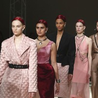 Dominasi Jill Kortleve berlanjut di fashion show Alexander McQueen. Jill (berada di barisan kedua) muncul dalam balutan dress dua warna, pink dan merah, yang dihiasi aksesori silver berupa statement necklace dan gelang futuristik. (Foto: AP/Thibault Camus)
