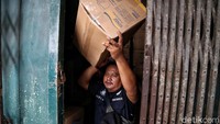 Petugas mengeluarkan kardus masker dari dalam gudang ke luar.