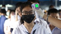 Selain mengenakan masker, para siswa juga turut diperiksa suhu tubuhnya dengan menggunakan thermal gun sebelum mengikuti ujian masuk sekolah menengah.