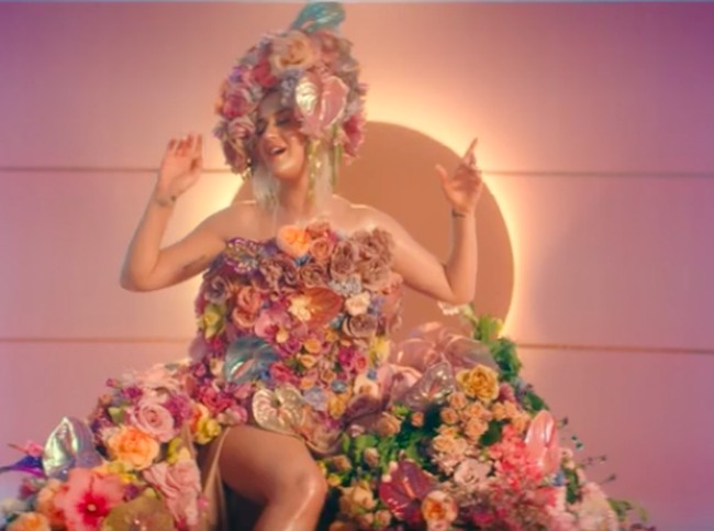 Gaya Katy kian sempurna dengan headpiece senada yang penuh warna. (Foto: screenshot youtube)