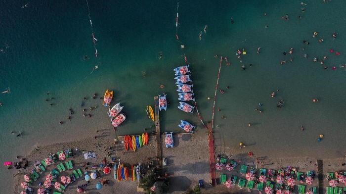 OLUDENIZ, TURKEY - AUGUST 16: People enjoy the beach on August 16, 2019 in Oludeniz, Turkey. Turkey’s resort towns saw a 100 percent occupancy rate with the Eid al-Adha holiday, including the southern province of Antalya and Aegean province of Muğla, the top two favorite destinations of both domestic and foreign tourists. According to the countrys statistical authority Turkeys tourism revenue hit nearly $8 billion in the second quarter of this year. (Photo by Burak Kara/Getty Images)