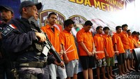 Para pelaku dihadirkan dengan penjagaan polisi bersenjata.