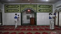 Dua orang petugas menyemprotkan desinfektan ke sejumlah bagian di dalam Masjid Hablul Mutaqqin.