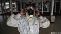 Para petugas tampak mengenakan pakaian pelindung, kacamata, serta masker pelindung pernapasan saat akan melakukan penyemprotan di masjid tersebut.
