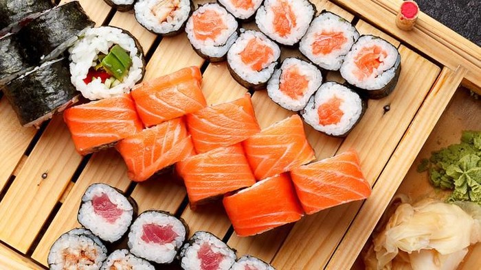 Big futomaki sushi with salmon, prawn tempura and cucumber
