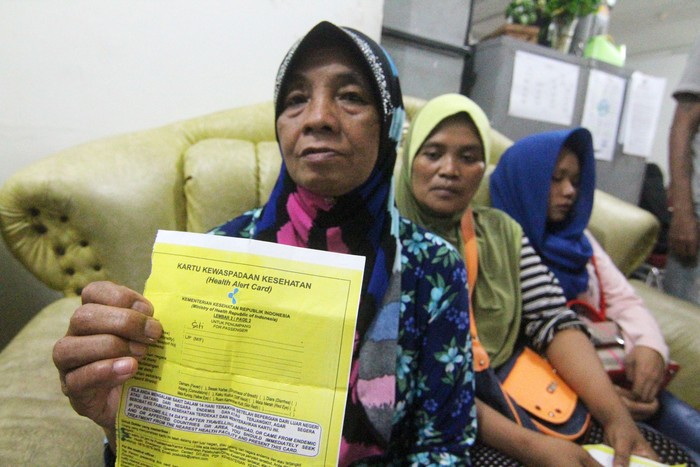 Pekerja Migran Indonesia (PMI) dari Malaysia mendapatkan layanan kesehatan dari petugas medis usai menjalani pendataan di Kantor Dinas Sosial Provinsi Kalimantan Barat di Pontianak, Kalimantan Barat, Kamis (5/3/2020) malam. Sebanyak 105 PMI bermasalah kembali dipulangkan Pemerintah Malaysia melalui Pos Lintas Batas Negara (PLBN) Entikong karena tidak memiliki paspor dan ijin kerja serta tersangkut kasus narkoba dan judi daring. ANTARA FOTO/Jessica Helena Wuysang/wsj.