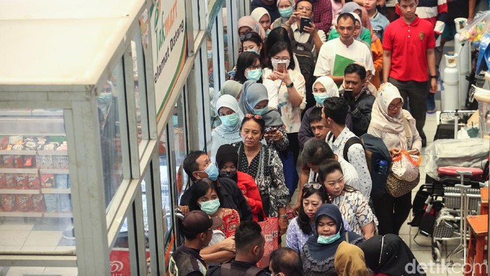Antrean warga tampak mengular panjang di kawasan Pasar Pramuka, Jakarta. Para warga rela antre berjam-jam untuk mendapatkan masker murah.