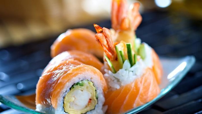 Big futomaki sushi with salmon, prawn tempura and cucumber