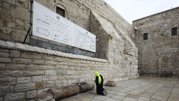 A pilgrim prays outside the Church of the Nativity in Bethlehem, West Bank, Thursday, March 5, 2020. Palestinian authorities said the Church of the Nativity in Bethlehem, built atop the spot where Christians believe Jesus was born, will close indefinitely due to coronavirus concerns. (AP Photo/Mahmoud Illean)