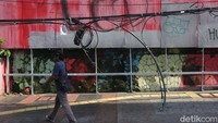 Para pejalan kaki terpaksa harus terganggu akibat kabel yang menjuntai.