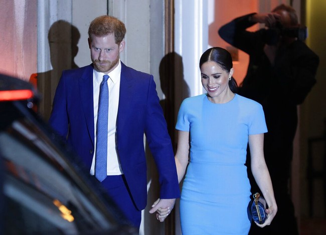 Mencoba tampil senada dengan Meghan, Pangeran Harry mengenakan setelan jas warna navy serta dasi yang juga berpalet sama. Foto: AP Photo/Kirsty Wigglesworth
