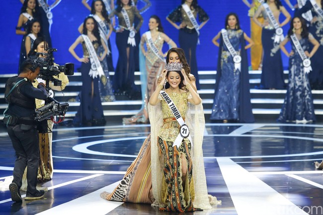 Ayu Maulida Putri dimahkotai oleh juara Puteri Indonesia 2019 Frederika Alexis Cull. Senyum pun mengembang di bibir Ayuma. Foto: Grandyos Zafna/Detikcom