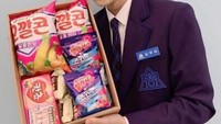 Kim Wooseok berpose dengan sekotak makanan ringan seperti keripik jagung, permen, kue, dan lainnya saat berkompetisi di Produce X 101. Foto: Istimewa
