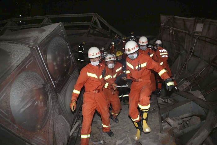 Hotel Tempat Karantina Corona di China Ambruk Rescuers help a man from the rubble of a collapsed hotel building in Quanzhou city in southeast China's Fujian province Saturday, March 7, 2020. The hotel used for medical observation of people who had contact with coronavirus patients collapsed in southeastern China on Saturday, trapping dozens, state media reported. (Chinatopix via AP)