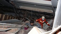 Salah seorang korban berusaha keluar dari puing-puing bangunan. Chinatopix Via AP.