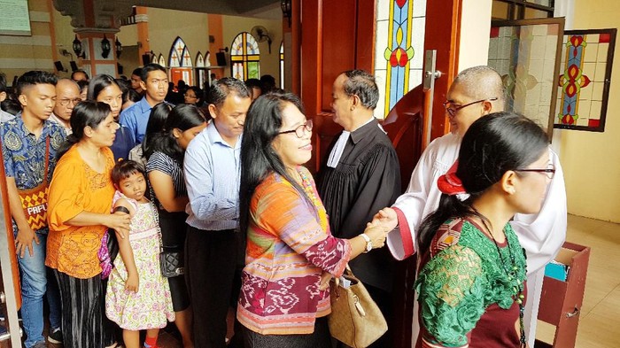 Jemaat gereja HKBP Lubuk Baja di Kota Batam tak menghentikan tradisi bersalaman usai ibadah di tengah penyebaran virus Corona.