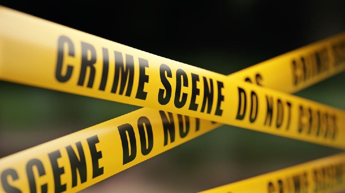 1059636358 Yellow crime scene do not cross barrier tape in front of defocused background. Horizontal composition with selective focus and copy space.