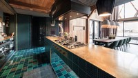 Warna-warna organik seperti tanah liat dan biru laut digunakan pada ubin lantai, dan detail furnitur menggabungkan kuningan dan baja. Istimewa/Inhabitat.