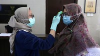 Satu per satu para pengawai Kemenko PMK diperiksa suhu tubuhnya.