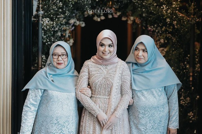 Tampilannya semakin anggun dengan tambahan selendang senada dengan gaunnya, serta memadukannya dengan hijab pink. Busananya ini didesain oleh Renzi Lazuardi.  Foto: Instagram @folklore.project