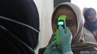 Para pegawai Kemenko PMK diperiksa menggunakan thermal gun.