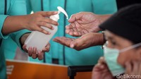 Satu per satu penumpang mendapat fasilitas antiseptik gratis dari petugas PT KAI di Stasiun Pasar Senen.