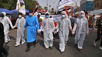 Sejumlah peserta aksi mengenakan pakaian khusus dan masker saat ikut serta dalam peringatan Hari Perempuan Internasional di Baghdad, Irak.