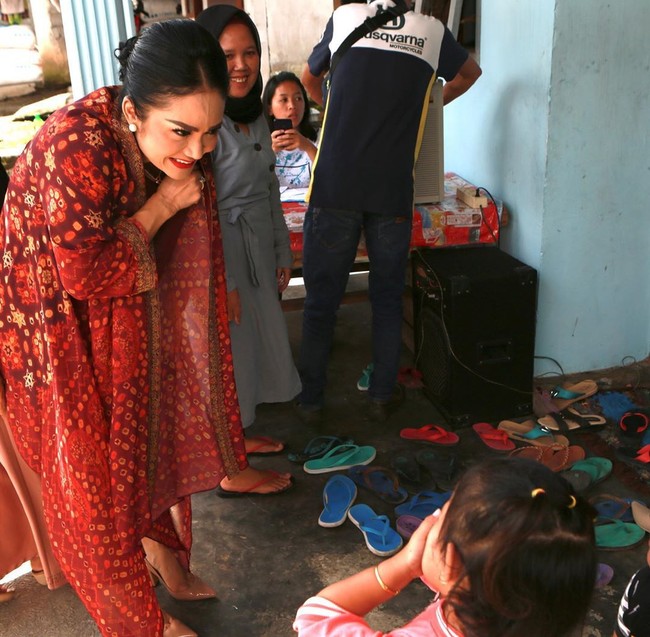 Melakukan edukasi dan sosialisasi mengenai virus Corona di Malang, Krisdayanti tampil cantik serba marun dengan blouse yang dilengkapi cardigan dari kain jumputan. Foto: Instagram/@krisdayantilemos