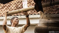 Terlihat seorang pekerja berupaya menyusun tumpukan bambu. Imam Kurniawan