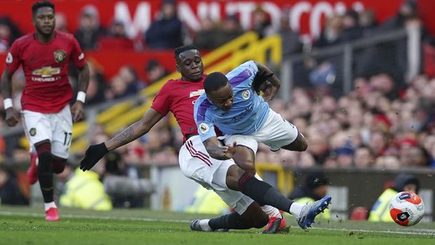 Manchester United's Aaron Wan-Bissaka and Manchester City's Raheem Sterling, right, compete for the ball during the English Premier League soccer match between Manchester United and Manchester City at Old Trafford in Manchester, England, Sunday, March 8, 2020. (AP Photo/Dave Thompson)