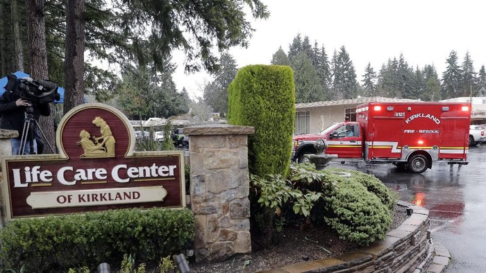 An ambulance backs into a parking lot, Friday, March 6, 2020, at the Life Care Center in Kirkland, Wash., which has become the epicenter of the COVID-19 coronavirus outbreak in Washington state. This ambulance left the facility after a short time and did not transport a patient. (AP Photo/Ted S. Warren)