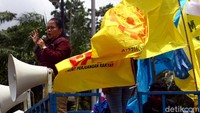 Salah seorang peserta aksi tampak melakukan orasi di atas mobil komando.