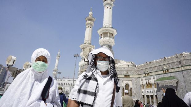 Muslim worshippers wear masks after the noon prayers outside the Grand Mosque, in the Muslim holy city of Mecca, Saudi Arabia, Saturday, March 7, 2020. Few worshippers were allowed to circumambulate the Kaaba, the cubic building at the Grand Mosque, over fears of the new coronavirus. (AP Photo/Amr Nabil)