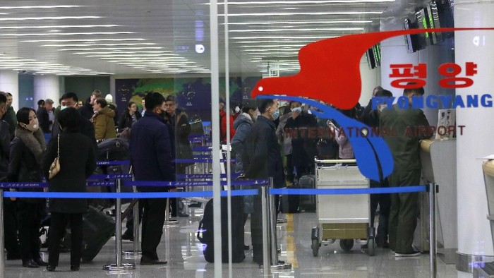 Passengers wearing masks as a precaution against a new coronavirus line up to check in for a flight to Vladivostok, Russia, at the Pyongyang International Airport in Pyongyang, North Korea, Monday, March 9, 2020. (AP Photo/Jon Chol Jin)