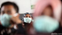 Sejumlah penumpang tampak mengenakan masker saat sedang menunggu kedatangan kereta di Stasiun Pasar Senen.