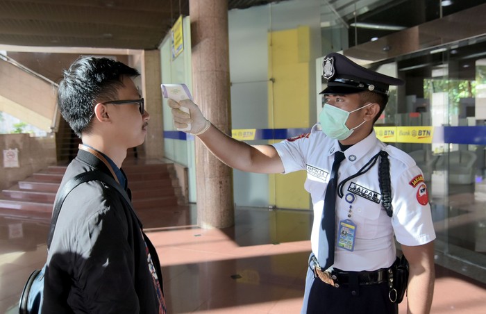 Minimalisir Penyebaran Virus Corona di Lingkungan Perbankan Petugas Keamanan PT Bank Tabungan Negara (Persero) Tbk. mengukur suhu para karyawan dan pengunjung yang akan masuk ke dalam lingkungan kerja perseroan, di Jakarta, Selasa (10/3). Begini potretnya.