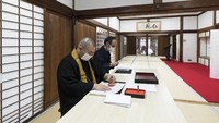 Seorang biksu (kiri) dan seorang petugas sedang membuat masker di Kuil Ninna-ji yang berada di kawasan Kyoto, Jepang.