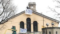 Para tahanan Penjara San Vittore itu tampak membentangkan spanduk yang berisi protes terkait aturan baru pencegahan penyebaran virus corona di area penjara. AP Photo/Antonio Calanni.