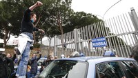 Seorang kerabat tahanan bahkan menaiki mobil yang terparkir di depan pagar Penjara Rebibbia saat melakukan aksi protes di depan penjara tersebut. AP Photo/Cecilia Fabiano/LaPresse.