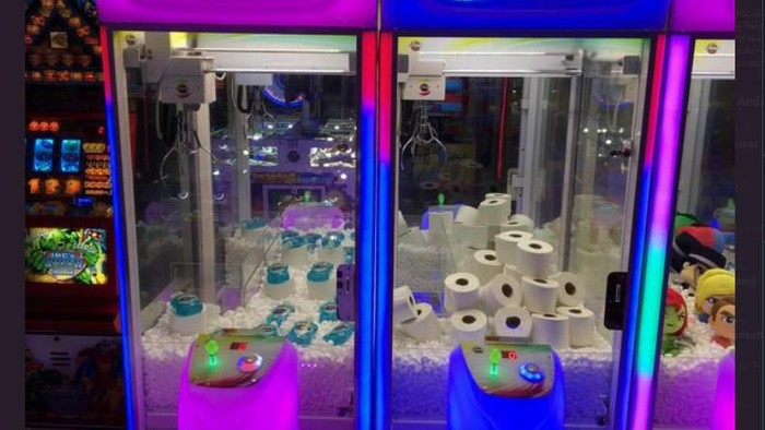 Mesin arcade mesin permainan yang berisi tisu toilet dan hand sanitizer.