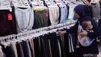 Seorang pengunjung sedang memilih pakaian impor di salah satu kios Pasar Metro Atom.